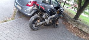 Na zdjęciu motocykl na tle pojazdu osobowego