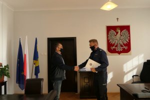 Na zdjęciu Komendant Powiatowy Policji w Zgorzelcu gratuluje mieszkańcowi Lubania