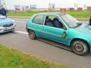 Na zdjęciu pojazd osobowy z urwanym lusterkiem z tyłu policyjny radiowóz