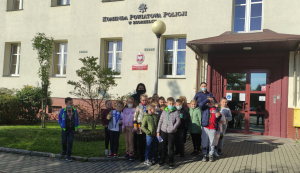 Na zdjęciu dzieci z policjantkami przed budynkiem komendy