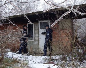 Na zdjęciu policjanci przy opuszczonym budynku