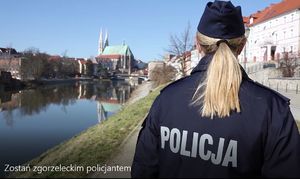 Na zdjęciu policjantka. W tle budynki mieszkalne