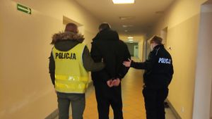 Na zdjęciu policjanci prowadzą mężczyznę w kajdankach. Zdjęcie poglądowe