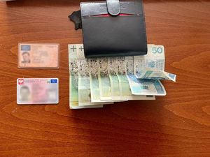 Na zdjęciu portfel, dokumenty i banknoty