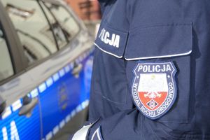 Na zdjęciu emblemat policyjny w tle radiowóz