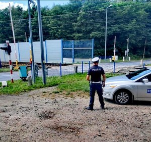 Na zdjęciu policjant przy przejeździe kolejowym