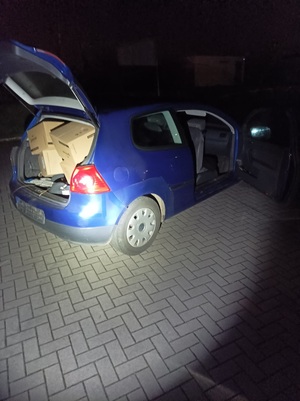 Na zdjęciu odzyskane skradzione kartony z ampułkami oraz pojazd sprawcy.