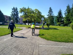 Na zdjęciu policjant i dziecko na rowerze