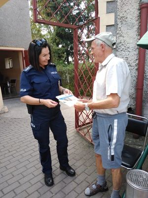 Na zdjęciu policjantka wręczająca materiały promocyjne