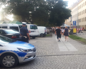 Na zdjęciu policjant z ruchu drogowego i radiowóz