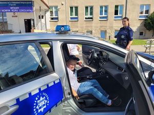 Na zdjęciu dziecko w radiowozu z boku policjantka