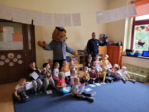 Na zdjęciu policjant, maskotka i dzieci