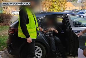 policjanci prowadzą zatrzymanego