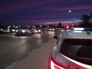 Na zdjęciu policyjny radiowóz w tle pojazdy