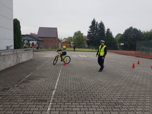 Na zdjęciu policjant i dziecko na rowerze