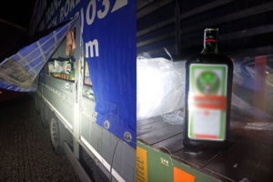 Na zdjęciu plandek od pojazdu ciężarowego i butelka alkoholu