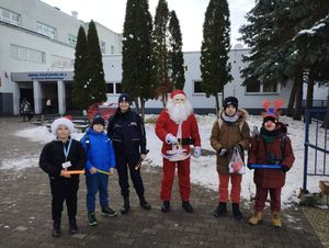 Na zdjęciu dzieci z Mikołajem i policjantką