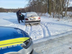 Na zdjęciu policyjny radiowóz, policjant i pojazd osobowy