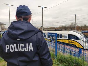 Na zdjęciu policjantka i pociąg