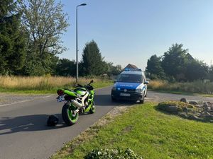 Na zdjęciu radiowóz i motocykl