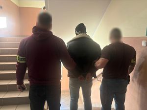 Na zdjęciu policjanci z zatrzymanym