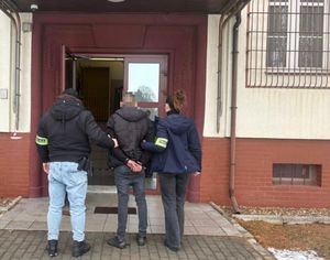 Na zdjęciu policjanci z podejrzanym