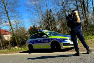 Na zdjęciu policjantka koło radiowozu