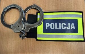 Na zdjęciu kajdanki i opaska z napisem policja