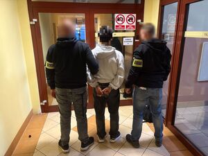 Na zdjęciu policjant i strażnik graniczny z zatrzymanym