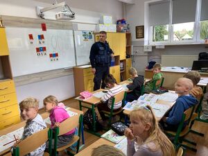 Na zdjęciu policjant i uczniowie
