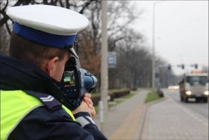 Na zdjęciu policjant mierzący prędkość