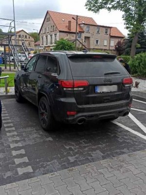 Na zdjęciu pojazd marki Jeep koloru czarnego ujęcie z tyłu