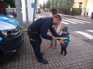 Na zdjęciu policjant z dzieckiem